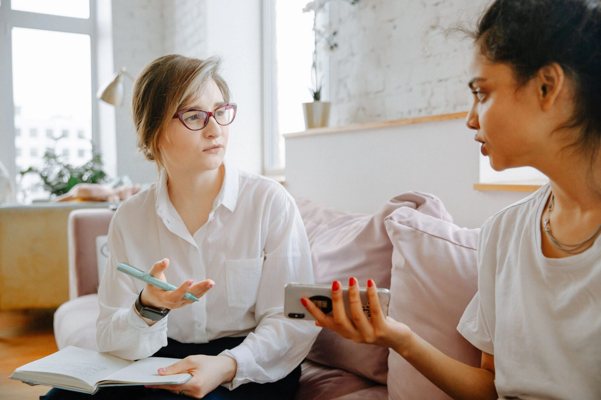 Pacientă discută cu terapeutul în timpul unei consultații psihologice, cu telefonul în mână, ilustrând impactul comportamentelor compulsive online asupra sănătății mintale și relațiilor.